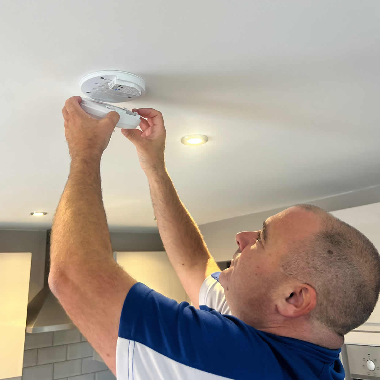 Smoke alarm installer fitting an alarm in a Walsall property